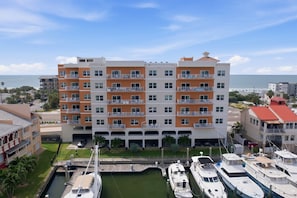 A multi-story hotel with balconies, a marina with boats, and a view of the ocean. - Coastal Retreat in Madeira Beach/Johns Pass (Madeira Beach)