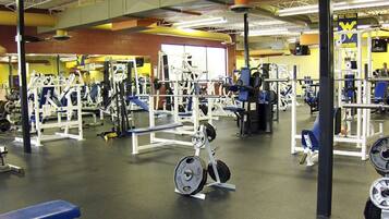 A gym with various exercise equipment, benches, and weightlifting stations.