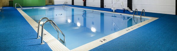 Una piscina con suelo de azulejos azules y una marca de profundidad de 3 pies.