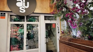A hotel entrance with a large sign, glass doors, a staircase, and potted plants. - Modern flat with sea views in Valencia. (Valencia)