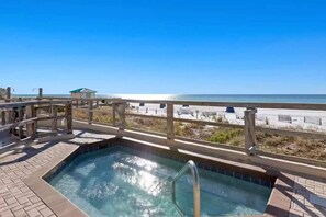 Ein Poolbereich mit Holzterrasse und Blick auf den Strand.