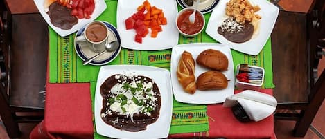 Una mesa con una variedad de platillos, tacos, un plato de enchiladas y una sopa.