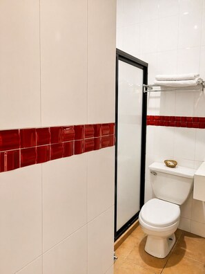 Habitación básica doble | Baño | Ducha, secador de pelo, toallas y jabón