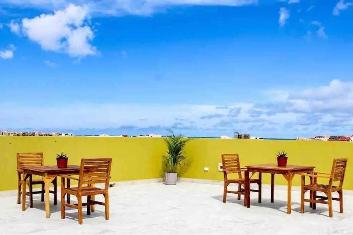 A rooftop with a swimming pool and outdoor seating.