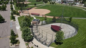 Luftaufnahme eines Baseballfeldes mit Stadion, Parkplatz und umgebender Bepflanzung.