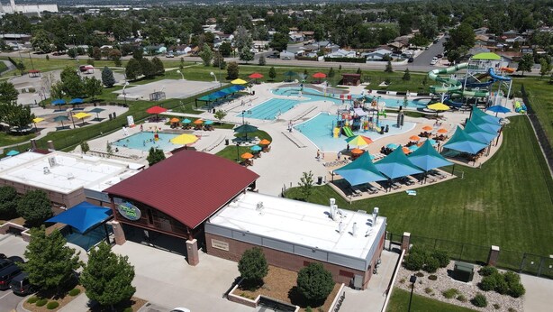 Ein Luftbild einer Freizeiteinrichtung mit Schwimmbad, Wasserrutschen und Parkplatz.