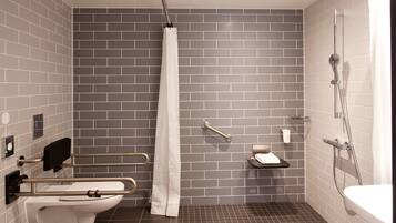 Un baño moderno con inodoro, ducha y barras de apoyo.