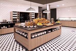 A modern kitchen with a central island, wooden cabinets, and a patterned floor. - Holiday Inn Express & Suites Basel Allschwil by IHG (Allschwil)