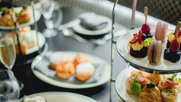 A multi-tiered dessert display with various pastries and fruits.