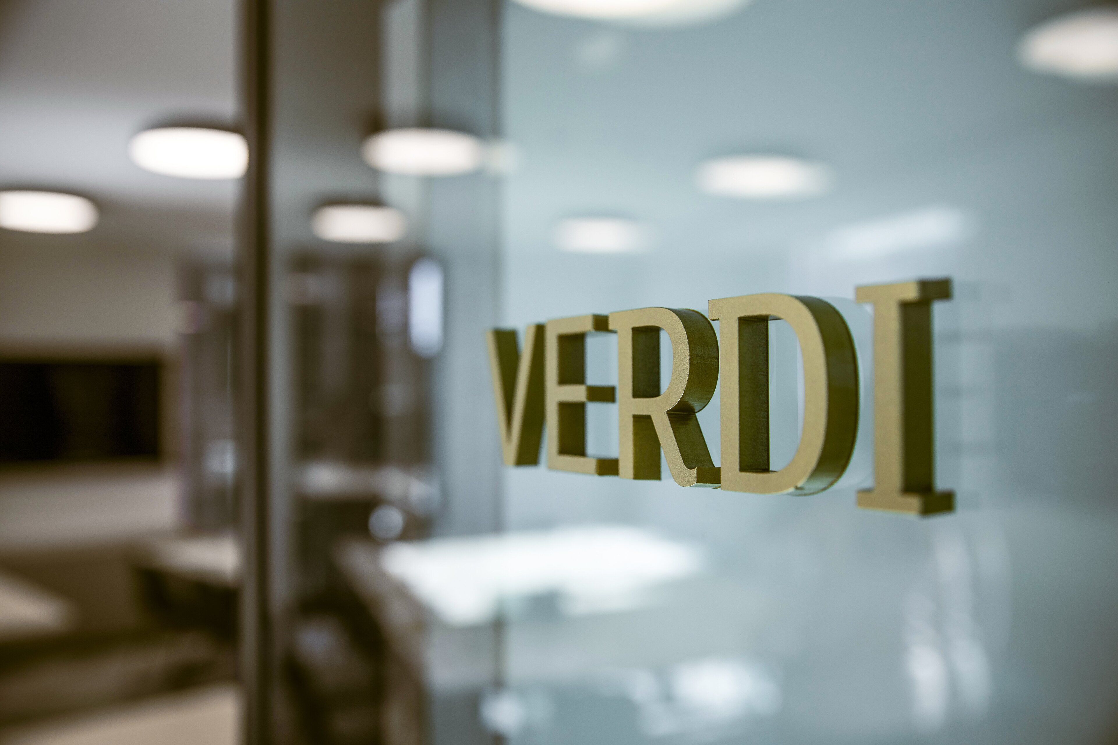 A close-up of a glass door with the word "VERDI" in gold letters.
