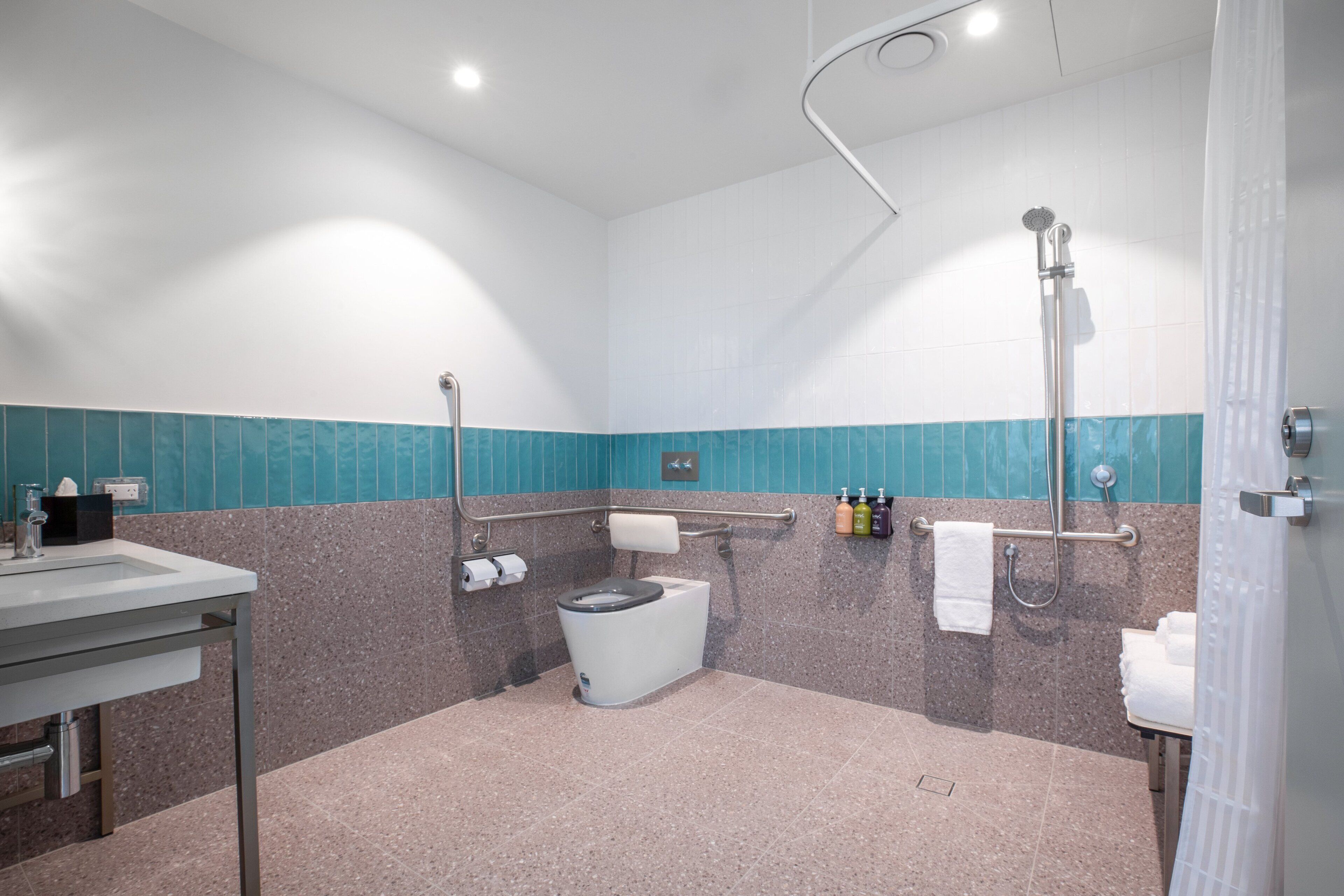 A modern bathroom with a toilet, sink, and shower.