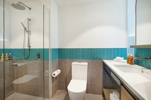 A modern bathroom with a glass-enclosed shower, a toilet, and a sink with a mirror. - Holiday Inn & Suites Geelong by IHG (Geelong)