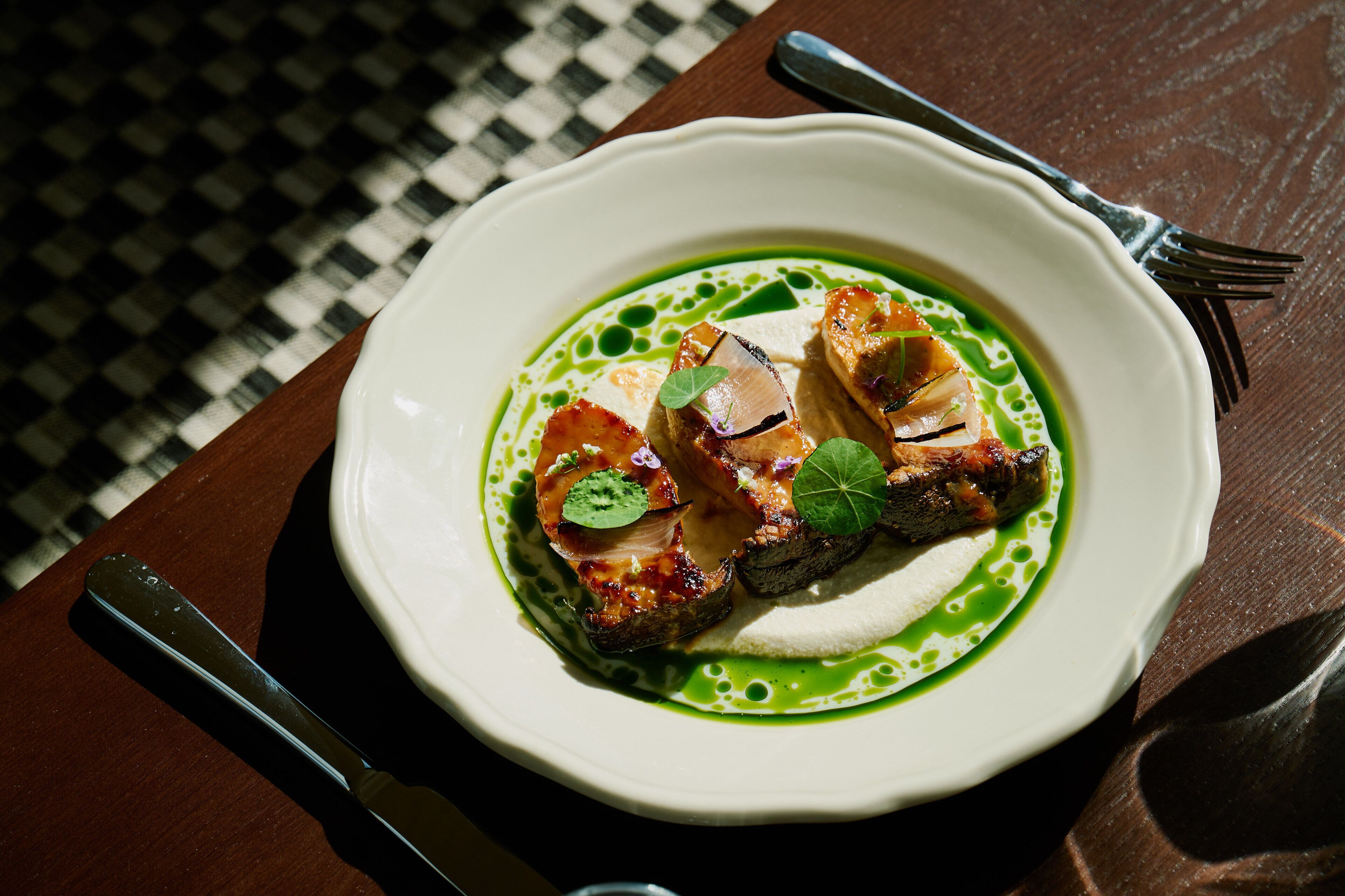 A plate of food with a fork and knife on a table.