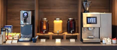 A coffee station with various brewing machines and containers.