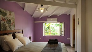 A bedroom with a bed, a window with a view of greenery, and a ceiling light fixture. - Full equiped Villa with swimming pool (Deshaies)