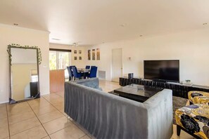 Relax in a spacious living area with a central seating space, dining table, and flat-screen TV.