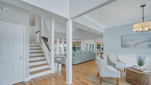 Un salón espacioso con escaleras, un sofá grande y una zona de comedor.