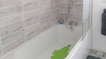 A bathroom with a bathtub, shower, and tiled walls.