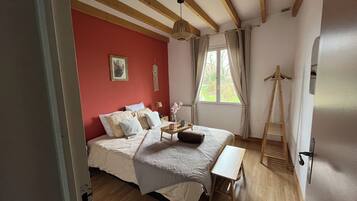 A bedroom with a bed, bedside table, and a wooden ladder.