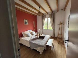 A bedroom with a bed, bedside table, and a wooden ladder. - Country house for 11 people with jacuzzi on the Opal Coast (Nabringhen)