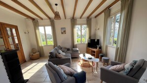 A spacious living room with a sofa set, a coffee table, and a television.