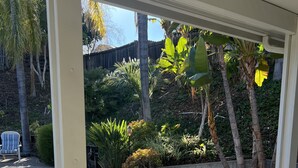 A covered patio area with a pool, outdoor furniture, and lush greenery. - Cheerful house 3 bed 4 bath pool house (Antioch)
