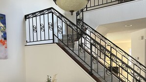 A dining area with a dark wooden table and chairs, a vase with flowers, and a decorative ceiling light. - Cheerful house 3 bed 4 bath pool house (Antioch)