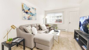 Ein modernes Wohnzimmer mit einer Couch, einem Couchtisch und einem Fernseher.