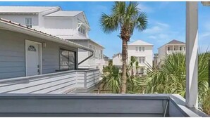 Un barrio residencial con casas blancas, una palmera y un cielo despejado.