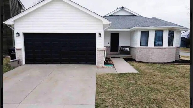 A residential house with a garage, a front porch, and a small front yard. - •Vibrant 4 bedroom house 2 king beds in Ankeny• (Ankeny)