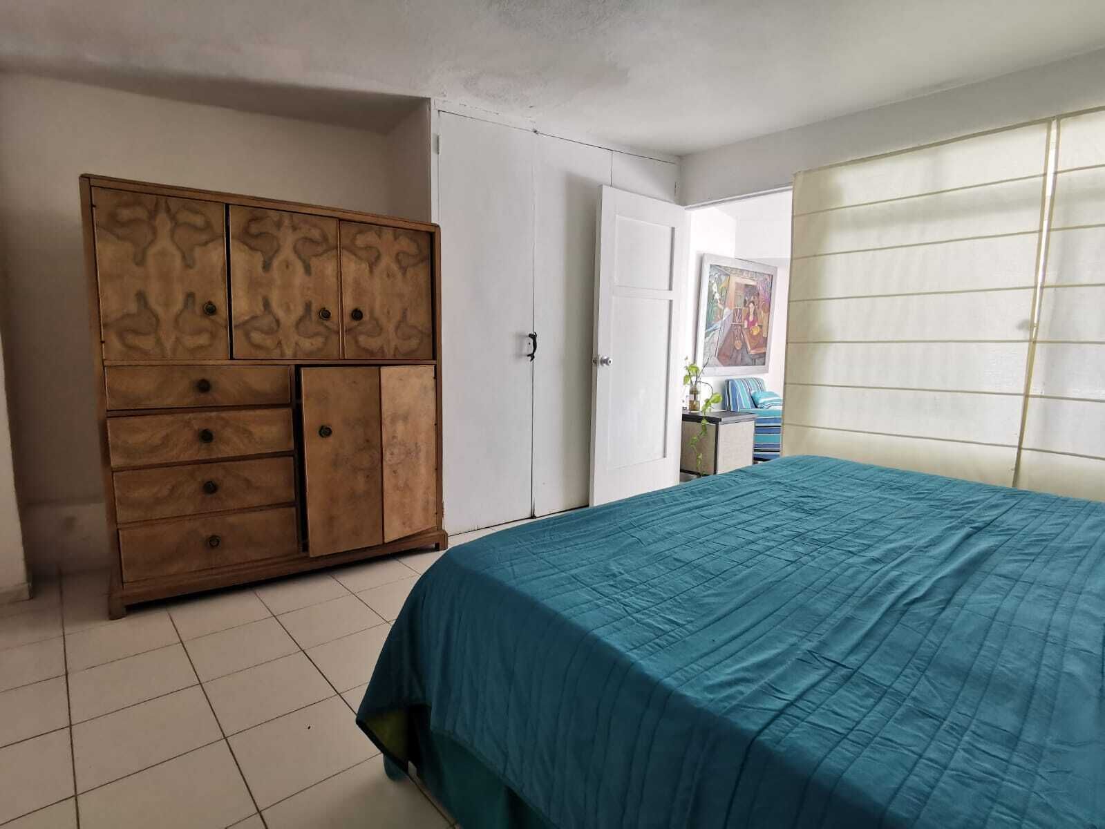 A bedroom with a bed, a wardrobe, and a door.