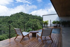 Een buitenzwembad, een infinity pool, ligstoelen bij het zwembad