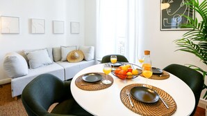 A modern dining area with a round table, black plates, and a fruit bowl. - Offline Mood Apartment (Faro)