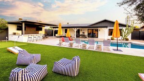 A modern house with a swimming pool, outdoor seating, and a patio area. - The Oasis: Luxe Heated Pool | Big Backyard | Outdoor Bar & BBQ for Large Groups (Scottsdale)