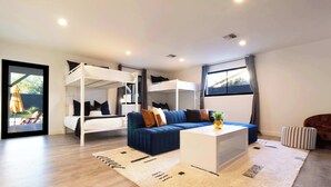 A modern living room with a sofa, a coffee table, and a bunk bed. - The Oasis: Luxe Heated Pool | Big Backyard | Outdoor Bar & BBQ for Large Groups (Scottsdale)