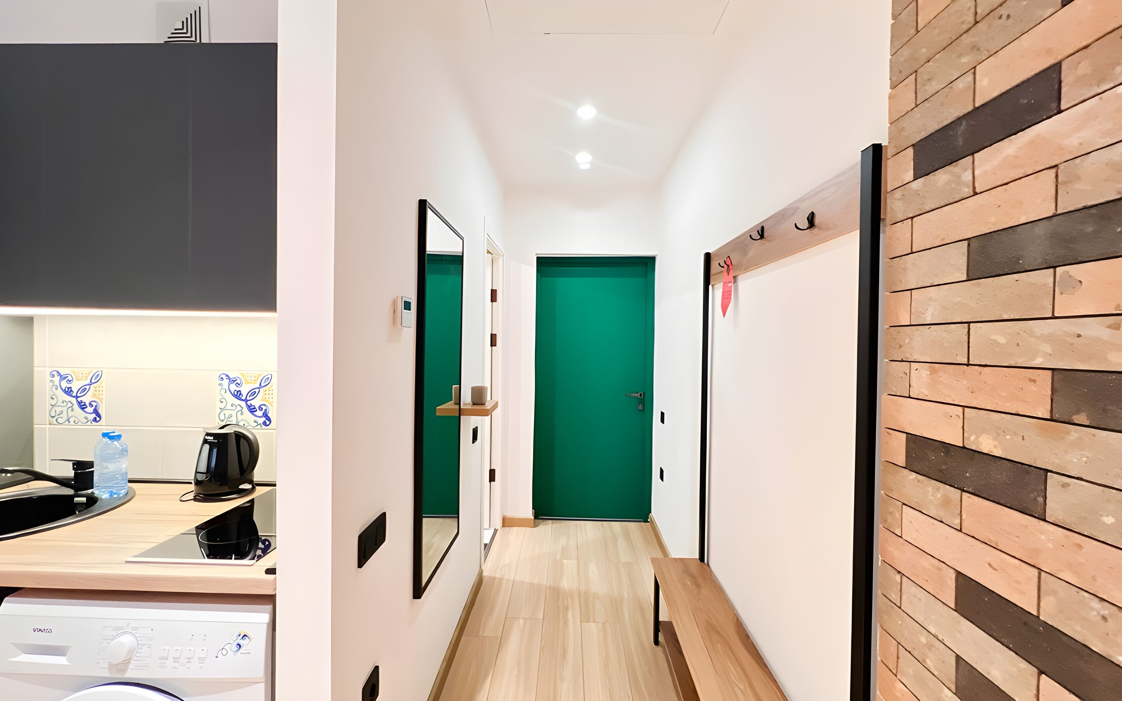 A modern kitchen with a built-in oven, a coffee machine, and a water dispenser.