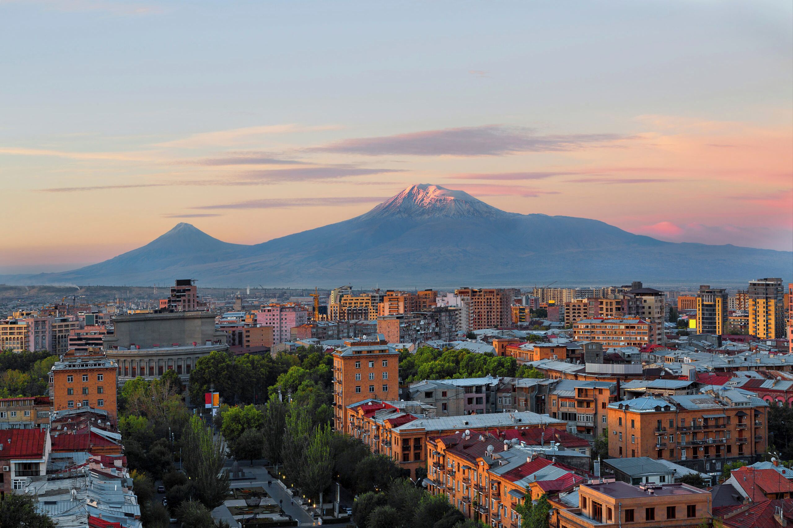 A cityscape with a prominent mountain in the background.