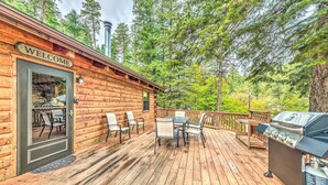 A wooden cabin with a 'WELCOME' sign, a deck with outdoor furniture, and a grill. - Updated Ruidoso Cabin w/ Spacious Deck & View (Ruidoso)