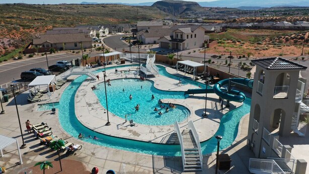 Una piscina con tobogán, sillas de descanso y vistas del paisaje circundante.