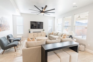 A modern living room with a ceiling fan, a flat-screen TV, and a sofa set. - Waterpark with slide, lazy river, pickleball court (Washington)