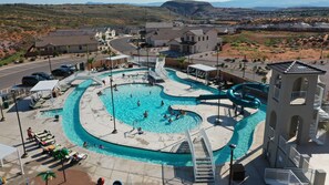 Une piscine avec un toboggan, des chaises longues et une vue sur le paysage environnant.