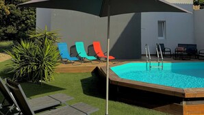A modern outdoor pool area with a pool, lounge chairs, and an umbrella. - Charming Bas de villa beach walking natural site (Venzolasca)