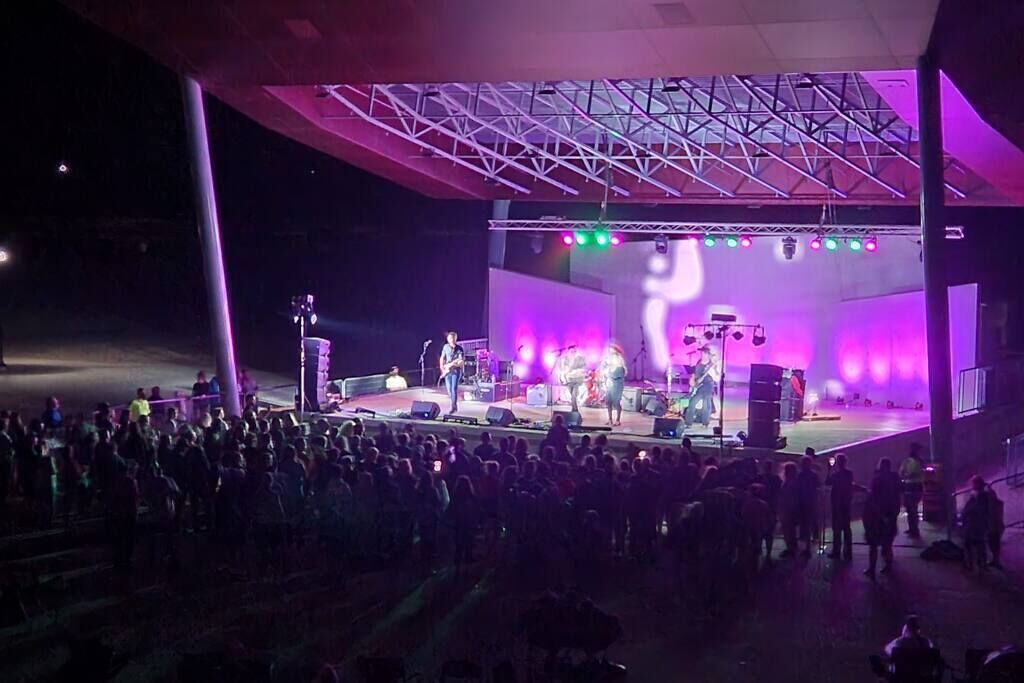 Une scène de concert avec une foule devant.
