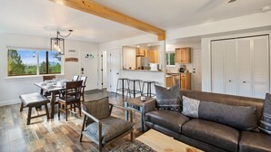 A spacious living area with a dining table, sofa, and kitchen in the background. - NEW Updated, SUNSETCABIN:3 bd,1.5 bth, secluded, beautiful views, deck, sleeps 6 (Florissant)