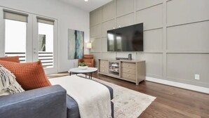 A modern living room with a sofa, a coffee table, a TV, and a cabinet.