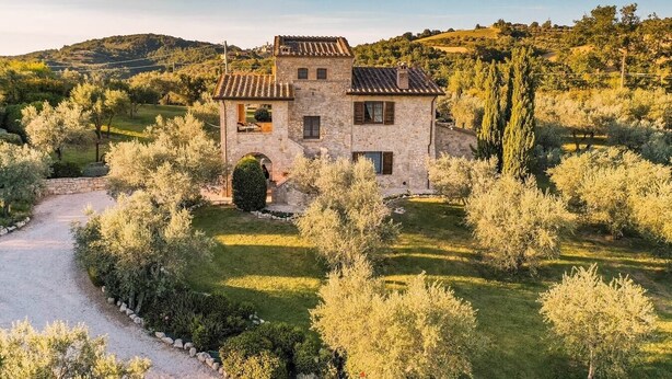 A stone house with a tiled roof surrounded by a well-maintained garden and trees. - Villa Ileana - Country villa with pool in Umbria (Collazzone)