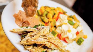 A plate with various food items including a piece of fried chicken, a salad, and some flatbread.