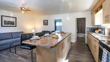 Enjoy a spacious living area with a comfortable sofa and dining area featuring a central island.