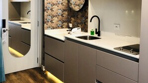 Una cocina compacta con un lavamanos, un espejo y una estufa.