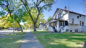 A two-story house with a front porch, a driveway, and a lawn.